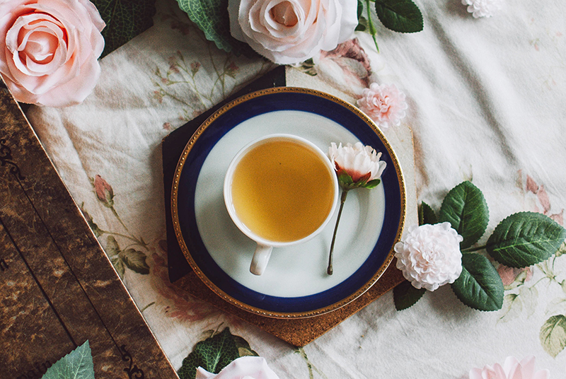 Image of hot tea surrounded by flowers 